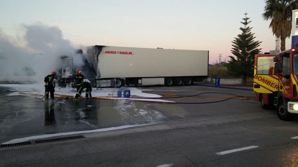 Los bomberos apagando el fuego del camión